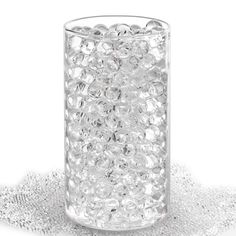 a glass filled with lots of bubbles on top of a white table cloth and silver sequins