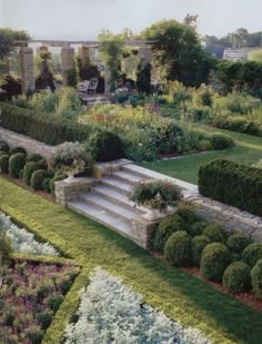 the garden is full of flowers and plants with steps leading up to it's center