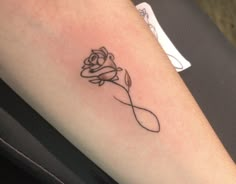 a tattoo with a rose on the left side of the arm that is black and white