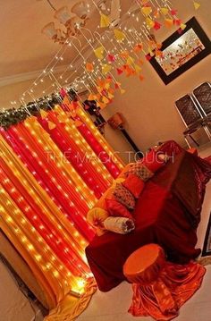 a living room filled with lots of furniture and lights hanging from the ceiling above it