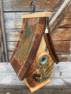 a wooden birdhouse with a bell on the roof