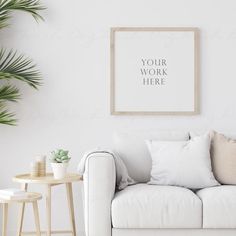 a living room with a white couch, table and potted plant in the corner