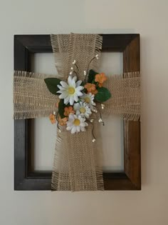 a cross made out of burlock with flowers on it is mounted to the wall