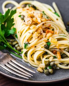 a plate full of pasta with peas and breadcrumbs next to a fork