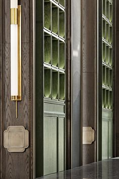 a large mirror sitting on the side of a wall next to a wooden cabinet with glass doors