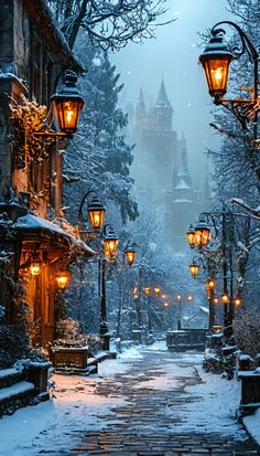 a snowy street with lights and buildings in the background