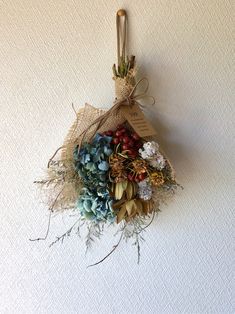 a bunch of dried flowers hanging on a wall with a tag attached to the back