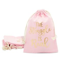 a pink bag with the words, the struggle is real in gold foil on it