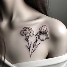 a woman's shoulder with two flowers on the left side of her body and one flower