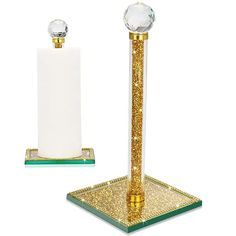 a gold and white candle holder with a crystal ball on it's top next to another one