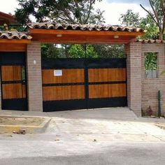 two garages with wooden doors and brick pillars