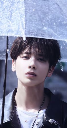 a young man holding an umbrella in the rain