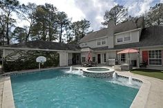 an outdoor swimming pool in front of a house