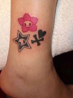 a person with a skull and star tattoo on their foot, next to a flower