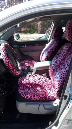 the interior of a car with pink and black leopard print seat covers on it's front seats