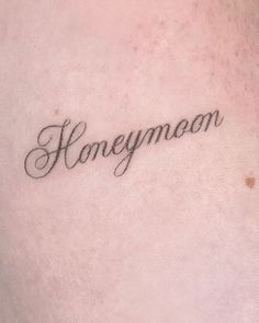 the word honeymoon written in cursive writing on someone's lower back