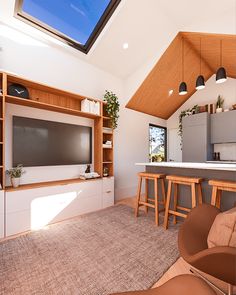 a living room filled with furniture and a flat screen tv on top of a wooden shelf