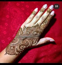 a woman's hand with henna tattoos on it