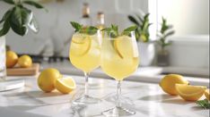 two glasses filled with lemonade sitting on top of a counter