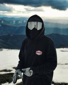 a person wearing ski goggles standing on top of a snow covered mountain