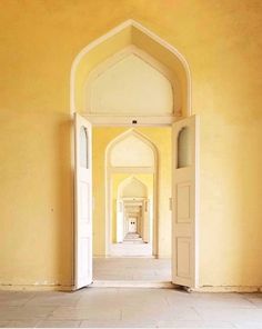 an open door leading into a hallway with yellow walls and white trim on the doors