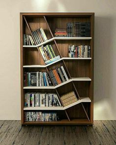 a bookshelf filled with lots of books on top of a wooden floor next to a wall