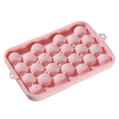 an egg tray filled with lots of small pink eggs on top of a white surface