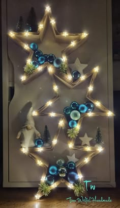 a christmas tree made out of wooden stars and blue baubles with lights on them