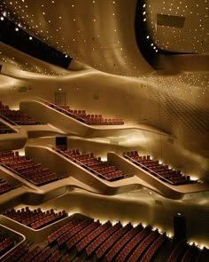 an empty auditorium with rows of seats and lights on the ceiling is lit up at night