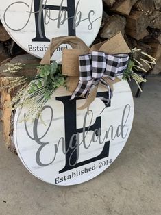 two wooden signs with the words happily married and an initial on each sign are decorated with greenery