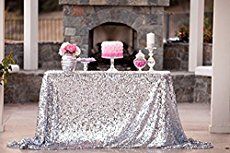 the table is covered with silver sequins and pink flowers, candles and cake