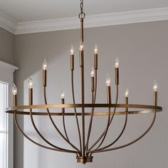 a large chandelier with candles hanging from it's centerpiece in a living room