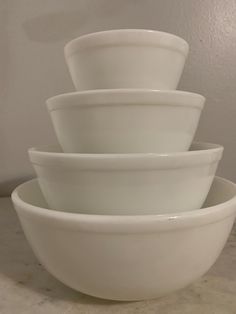 four white bowls stacked on top of each other