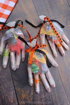 four halloween handprinted hands tied together with orange and black ribbon on top of them