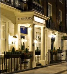 the tophams hotel in london is lit up at night with its lights on