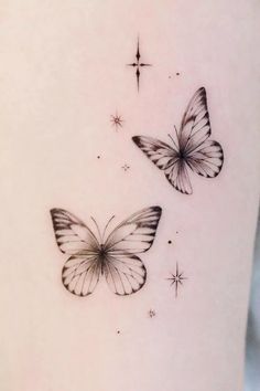 two butterflies on the back of a woman's thigh, with stars in the background