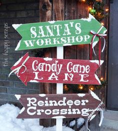 three wooden signs that say santa's workshop, candy cone lane and reindeer crossing