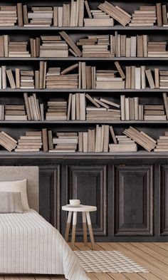 a bed sitting in front of a book shelf filled with books on top of it