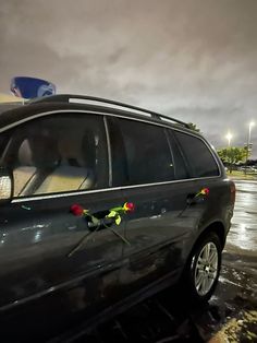 a car parked in a parking lot with its door open and flowers on the side