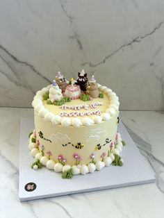 a birthday cake decorated with animals and flowers