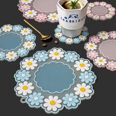 a table topped with plates and cups filled with coffee next to spoons on top of a black surface