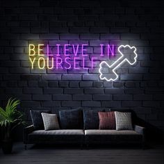 a neon sign that says, be believe in yourself on the wall next to a couch