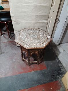 a small table sitting on top of a floor next to two stools