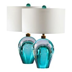 two blue glass lamps sitting next to each other on top of a white lamp shade