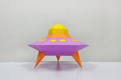 an origami model of a purple and yellow space ship