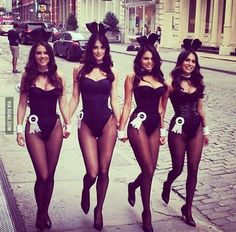 three women dressed in bunny costumes walking down the street with their hands in their pockets