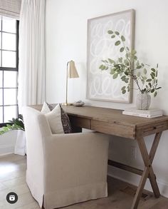 a white chair sitting next to a wooden desk with a plant on top of it