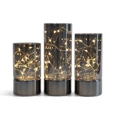 three glass vases with lights in them