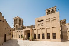 an old building in the middle of a desert with two towers on each side and plants growing out of the windows