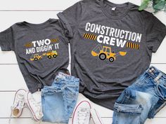 two construction crew shirts sitting next to each other on top of a white wooden floor